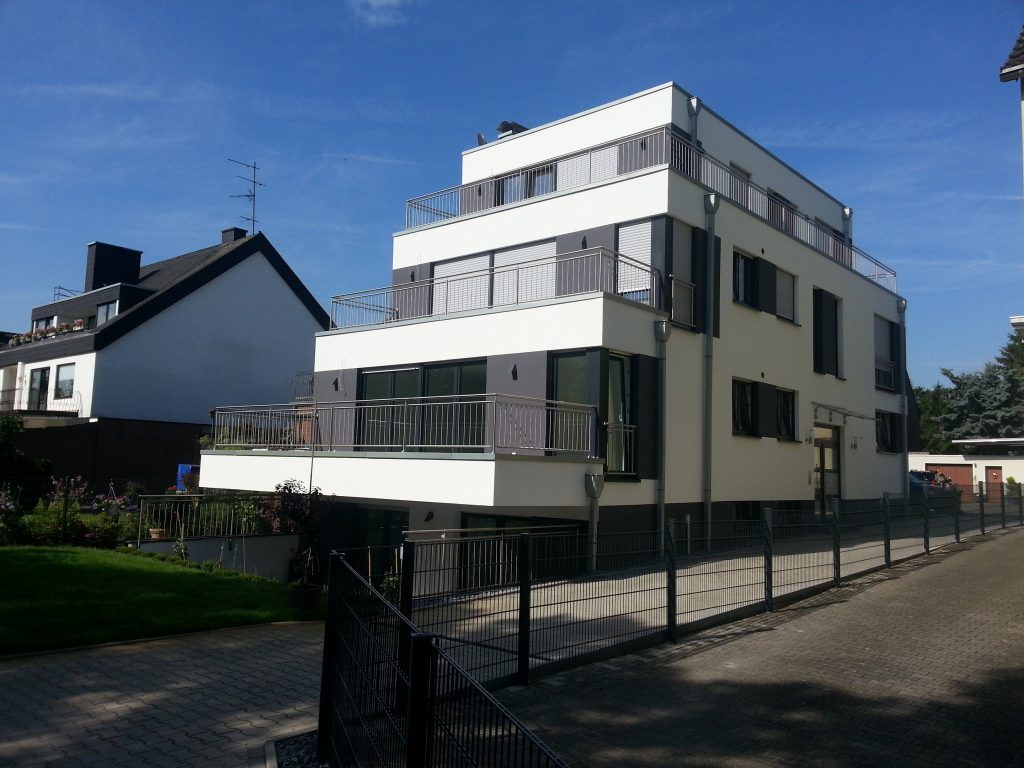Weißes Mehrfamilienhaus mit Staffelgeschoss und Dachterrassen
