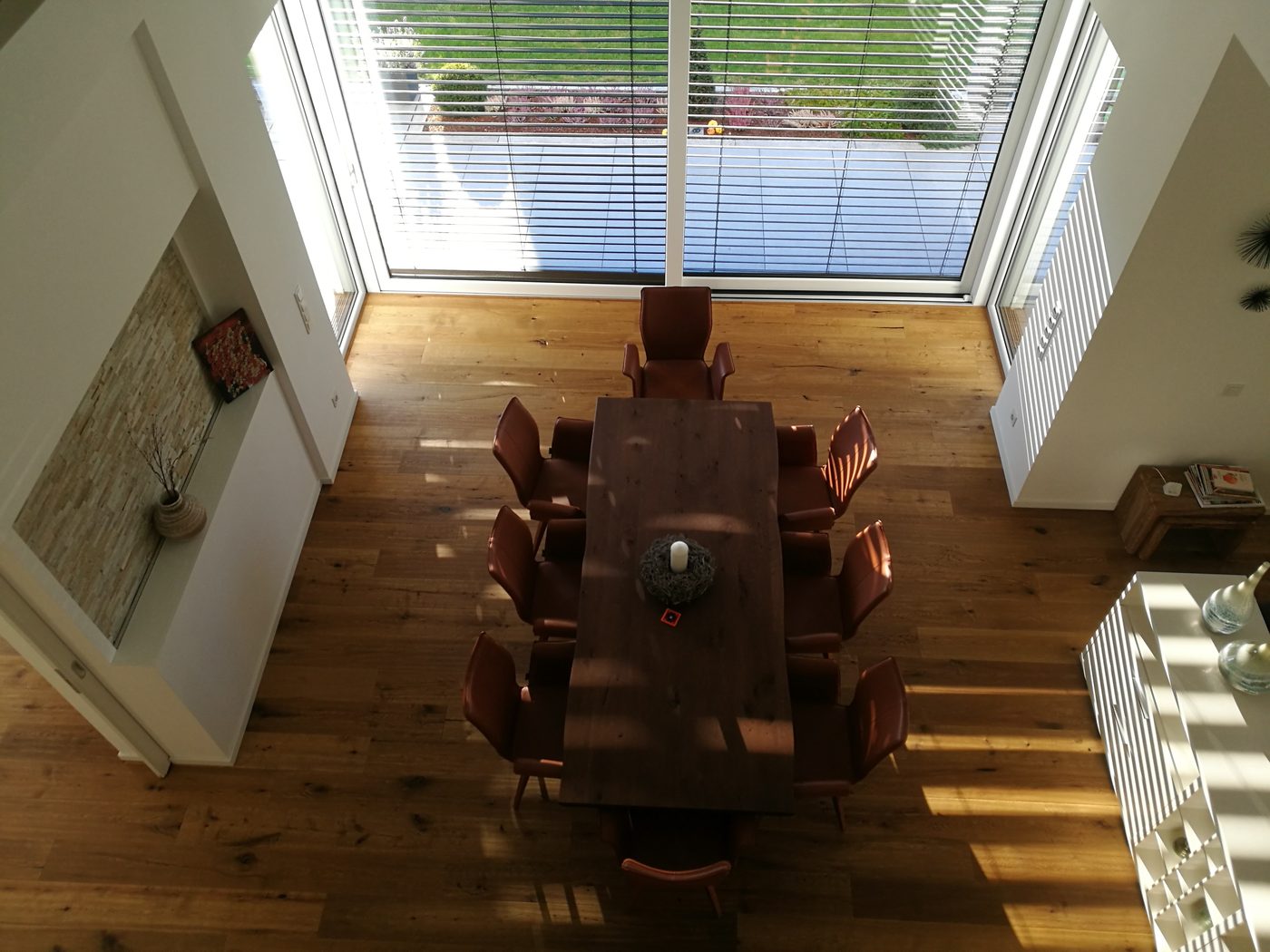 Blick von der Galerie auf einen Esstisch in einem Wohnhaus mit Holzboden