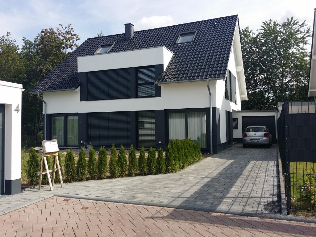 Neu gebautes Einfamilienhaus mit dunklem Dach und Garage