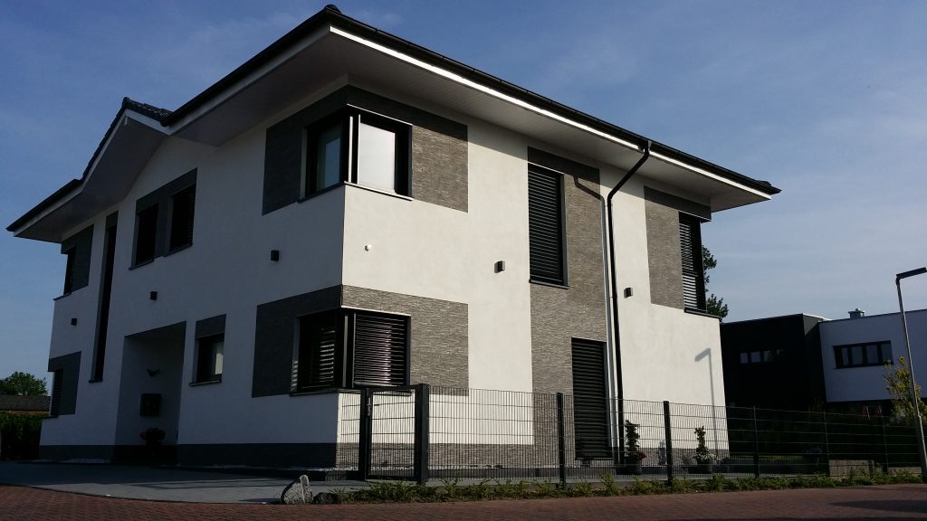 Zweigeschossiges Wohnhaus mit Klinker- und Putzfassade in der Abendsonne